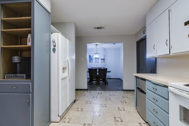 kitchen featuring white cabinetry, tasteful backsplash, decorative light fixtures, a notable chandelier, and white appliances