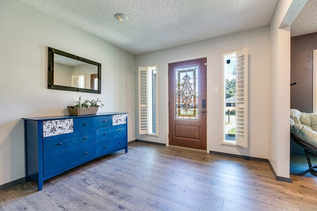 foyer with light hardwood / wood-style floors and a textured ceiling