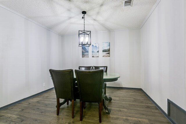 dining area with crown molding, dark wood-type flooring, a chandelier, and a textured ceiling