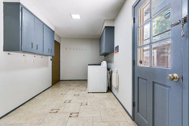 clothes washing area featuring cabinets, washer / clothes dryer, and a textured ceiling