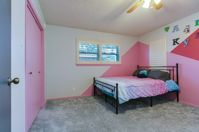 bedroom with ceiling fan, light carpet, a textured ceiling, and a closet