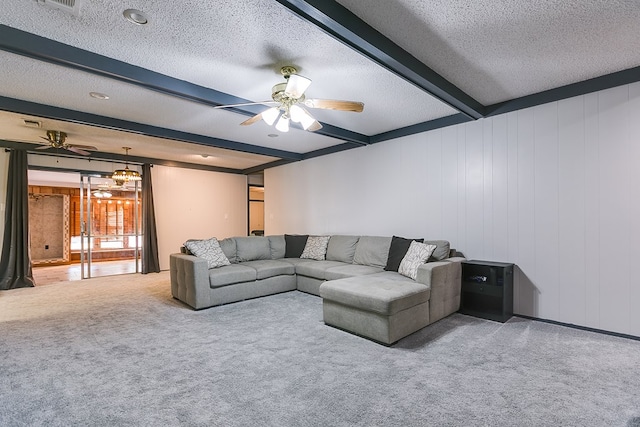 carpeted living room featuring beamed ceiling, ceiling fan, and a textured ceiling