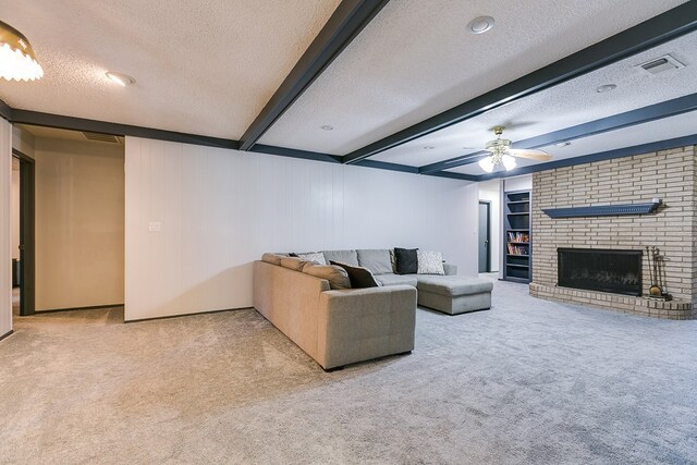 living room with beam ceiling, light carpet, a textured ceiling, ceiling fan, and a fireplace