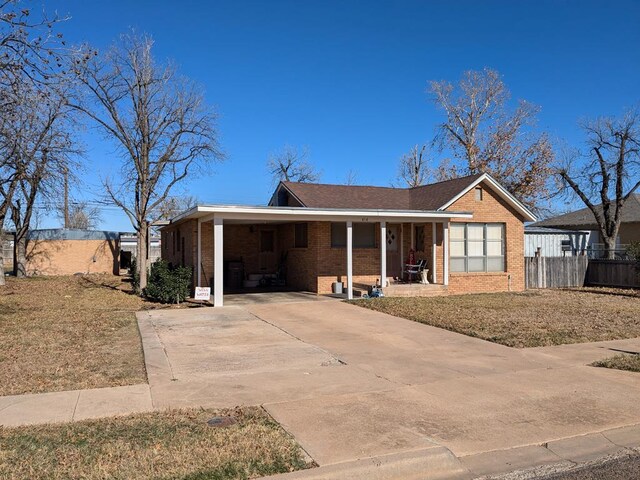 ranch-style home with a carport, covered porch, and a front lawn