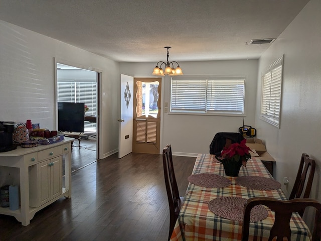 dining area with an inviting chandelier, dark hardwood / wood-style flooring, and a wealth of natural light