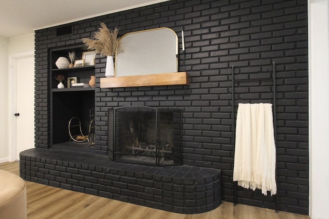 living room with hardwood / wood-style flooring, a textured ceiling, and a fireplace