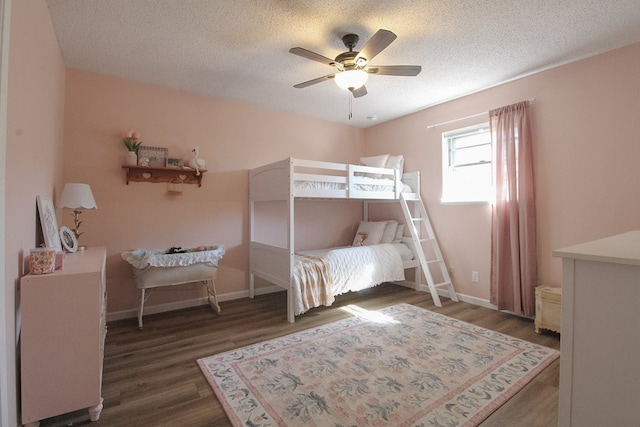 bedroom featuring dark hardwood / wood-style flooring, a textured ceiling, and ceiling fan