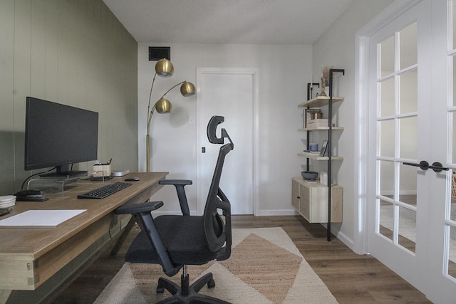 home office with dark hardwood / wood-style floors and french doors