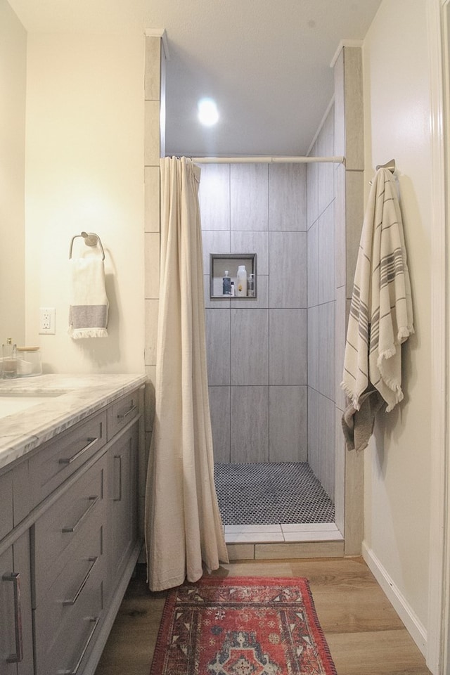 bathroom with a shower with curtain, wood-type flooring, and vanity