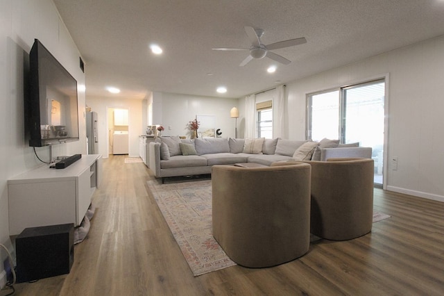 living room with ceiling fan, washer / clothes dryer, and light hardwood / wood-style floors