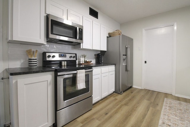 kitchen featuring white cabinetry, appliances with stainless steel finishes, light hardwood / wood-style floors, and backsplash