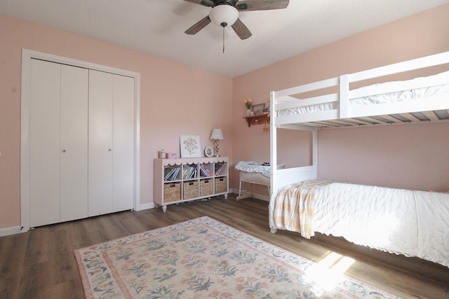 bedroom featuring ceiling fan, dark hardwood / wood-style floors, and a closet