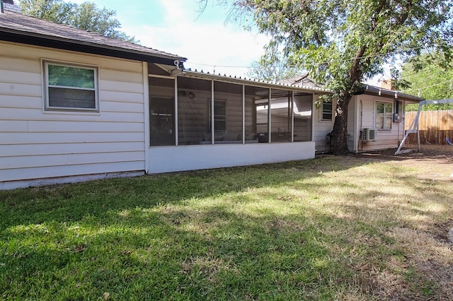 back of house with a sunroom and a lawn