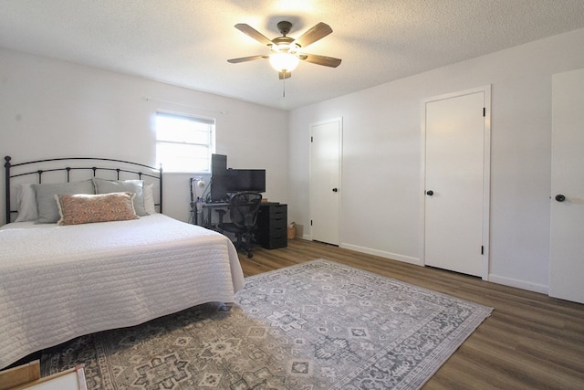 bedroom featuring ceiling fan, wood-type flooring, and a textured ceiling