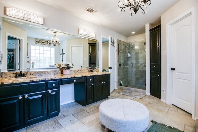6023 Warwick Dr, San Angelo, TX 76904 - full bath featuring a chandelier, a shower stall, double vanity, and a walk in closet
