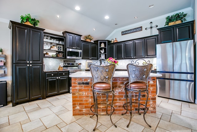 6023 Warwick Dr, San Angelo, TX 76904 - kitchen featuring stainless steel appliances, open shelves, vaulted ceiling, dark cabinets, and ornamental molding