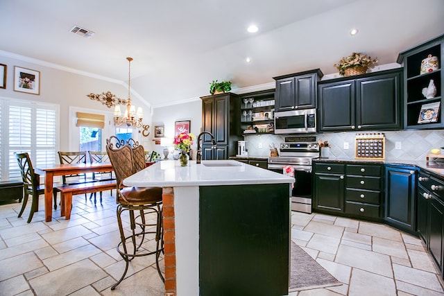 6023 Warwick Dr, San Angelo, TX 76904 - kitchen with appliances with stainless steel finishes, open shelves, vaulted ceiling, tasteful backsplash, and a breakfast bar area