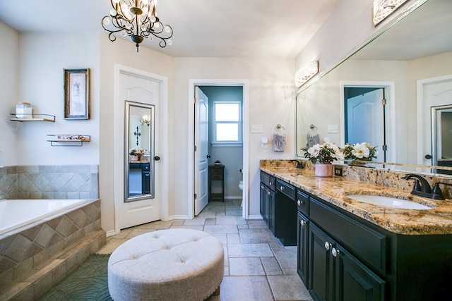 6023 Warwick Dr, San Angelo, TX 76904 - bathroom featuring double vanity, a bath, and a chandelier