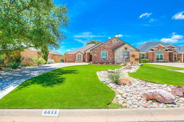 6023 Warwick Dr, San Angelo, TX 76904 - view of front of house featuring a front lawn, brick siding, and driveway