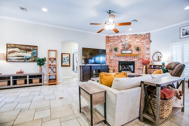 6023 Warwick Dr, San Angelo, TX 76904 - living room featuring arched walkways, ceiling fan, crown molding, a fireplace, and stone tile floors