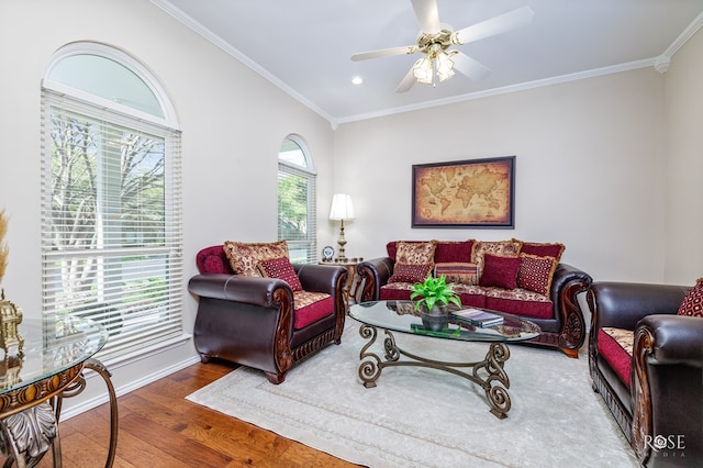 living room featuring a wealth of natural light, wood finished floors, ceiling fan, and ornamental molding