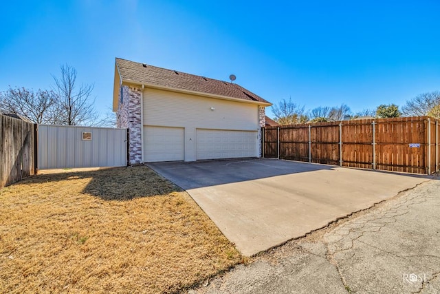 view of home's exterior featuring driveway, a garage, and fence