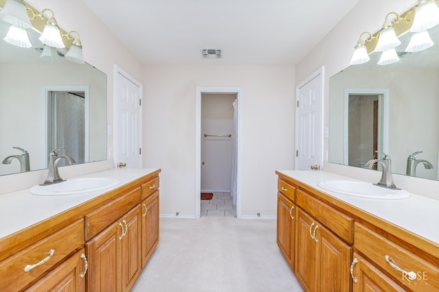 full bathroom featuring baseboards, visible vents, a sink, and two vanities