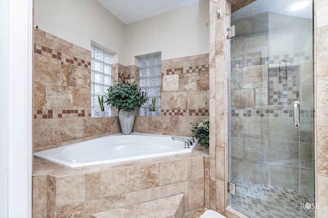 bathroom with a shower stall and a garden tub