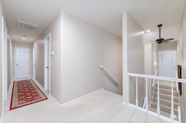 corridor featuring baseboards, carpet floors, an upstairs landing, and visible vents
