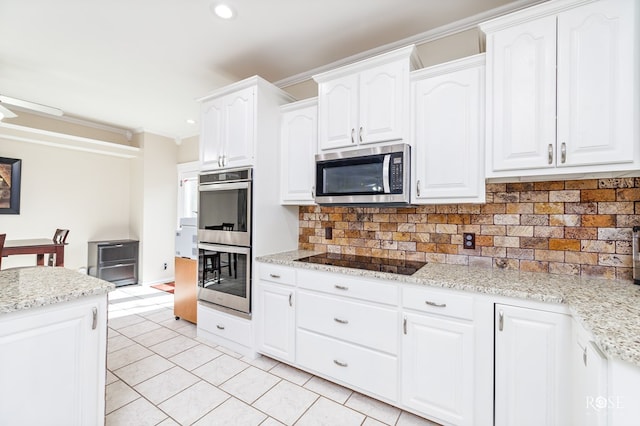 kitchen featuring white cabinets, crown molding, stainless steel appliances, tasteful backsplash, and light tile patterned floors