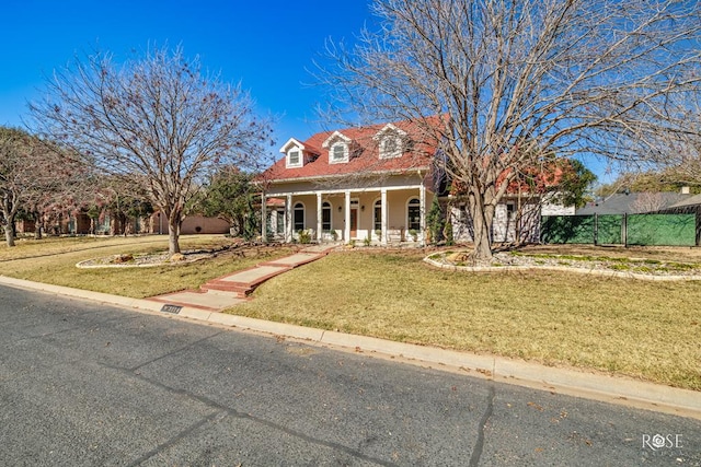 new england style home featuring covered porch and a front lawn