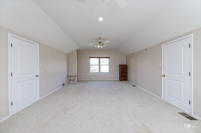 additional living space with visible vents, baseboards, ceiling fan, lofted ceiling, and light colored carpet