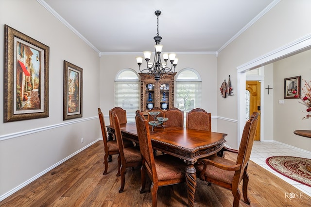 dining space featuring ornamental molding, a chandelier, and wood finished floors