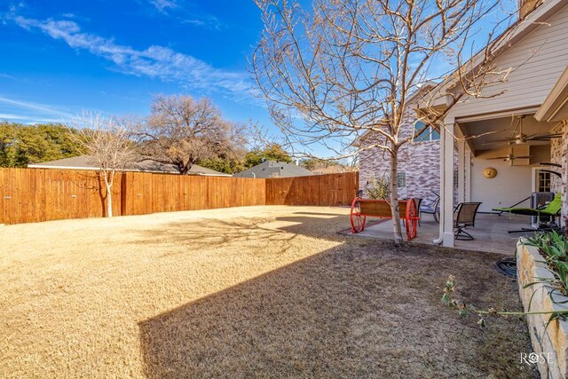 view of yard with a fenced backyard, a ceiling fan, and a patio area
