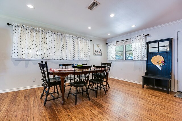 dining area with ornamental molding and wood-type flooring