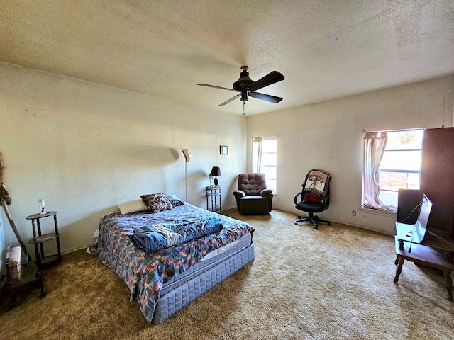 carpeted bedroom featuring ceiling fan, multiple windows, and a textured ceiling