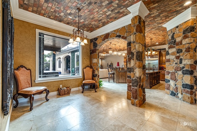 sitting room with ornamental molding, sink, a chandelier, and brick ceiling