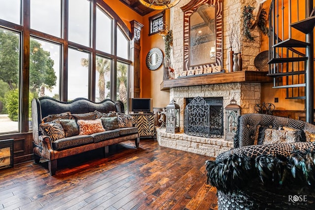 interior space with a wealth of natural light, wood-type flooring, a high ceiling, and a fireplace