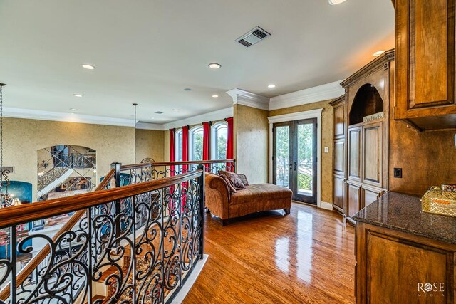 corridor with french doors, hardwood / wood-style flooring, and crown molding