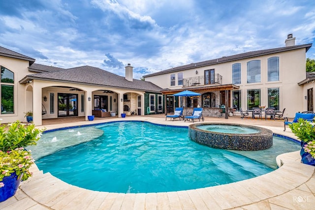 view of swimming pool with pool water feature, an in ground hot tub, ceiling fan, and a patio area