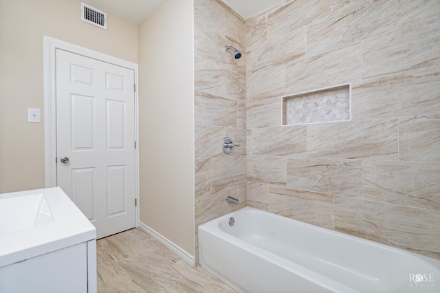 bathroom with vanity and tiled shower / bath combo