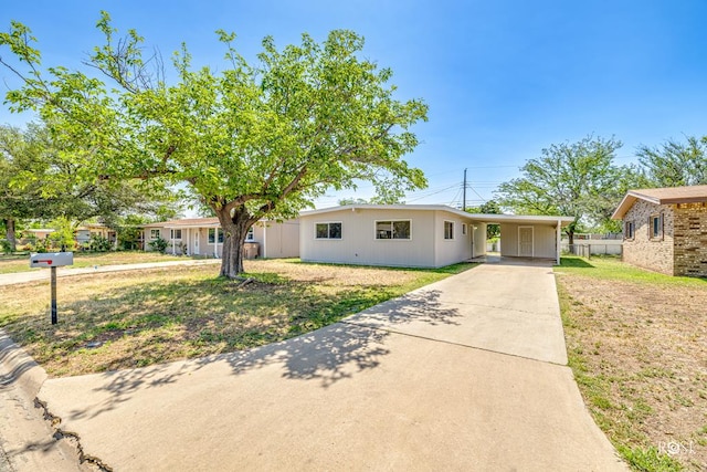 ranch-style home with a carport and a front yard