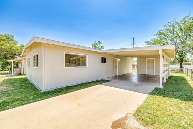 manufactured / mobile home featuring a carport and a front lawn