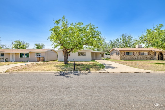 ranch-style home with a carport and a front lawn