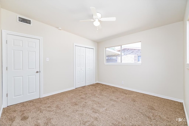 unfurnished bedroom featuring carpet floors, a closet, and ceiling fan