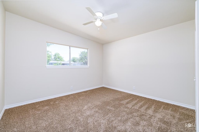 empty room featuring ceiling fan, lofted ceiling, and carpet flooring