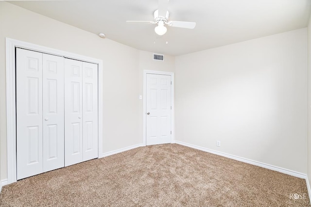 unfurnished bedroom with carpet flooring, ceiling fan, and a closet