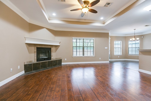 unfurnished living room with crown molding, a raised ceiling, and a healthy amount of sunlight