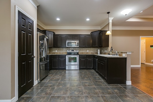 kitchen featuring appliances with stainless steel finishes, decorative light fixtures, sink, and stone counters