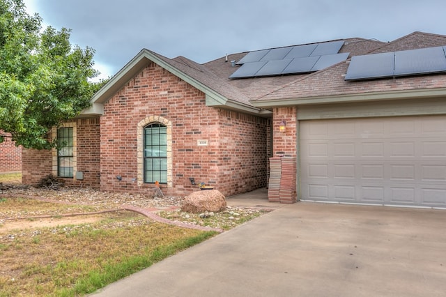 view of front of house featuring a garage and solar panels